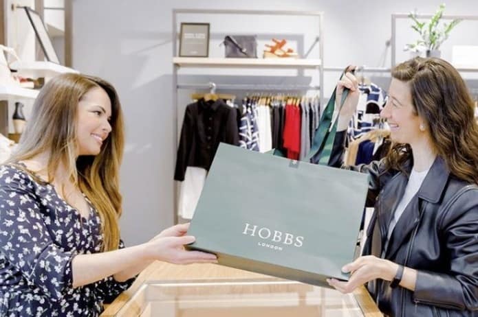 A shopper collects her Hobbs purchase in-store. Image courtesy of Hobbs/OneStock