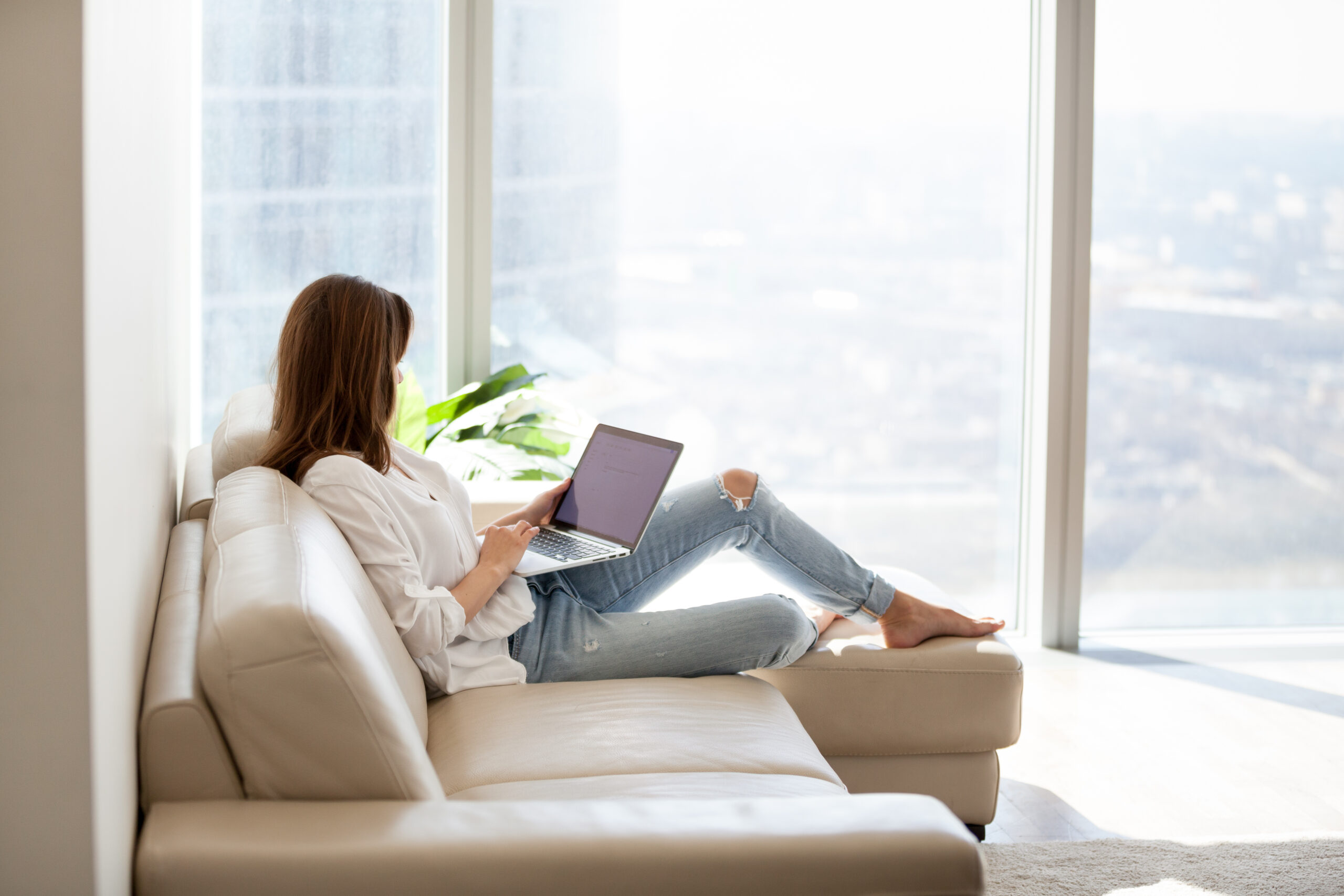 Relaxed,Woman,Using,Laptop,In,Luxury,Home,Living,Room,With