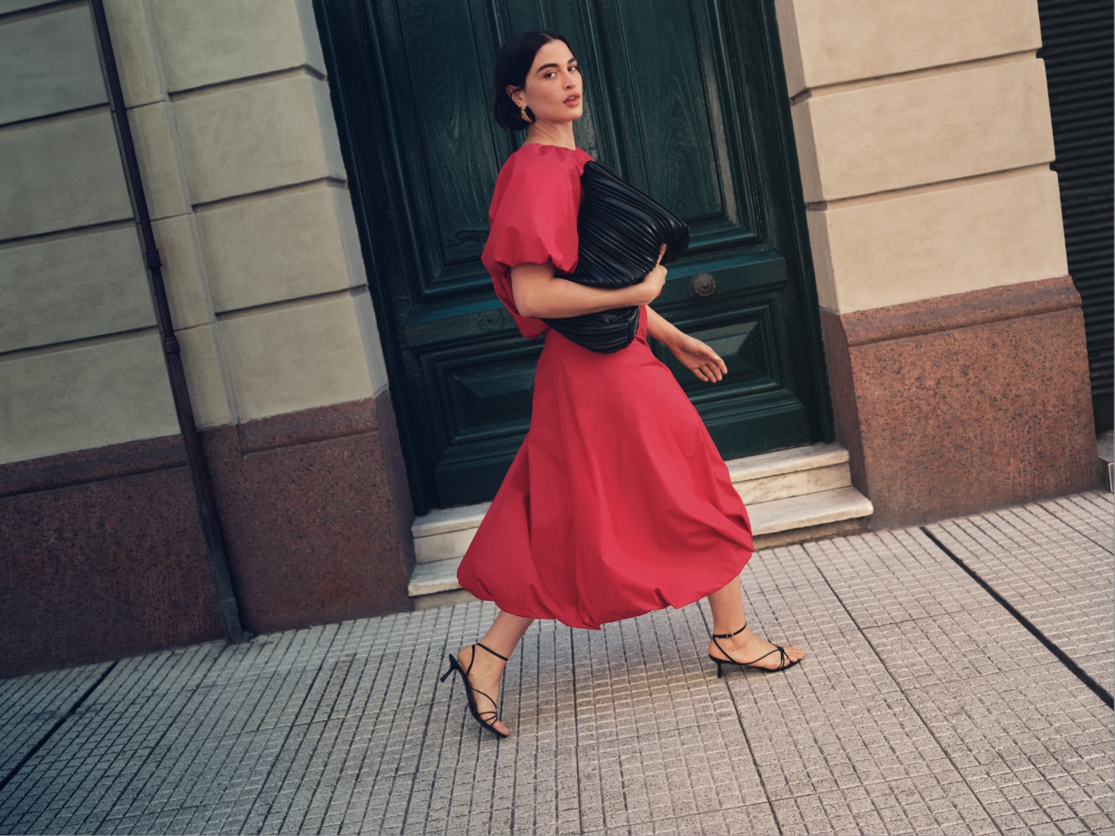 A woman wearing an M&S dress walks along a pavement. Image courtesy of M&S